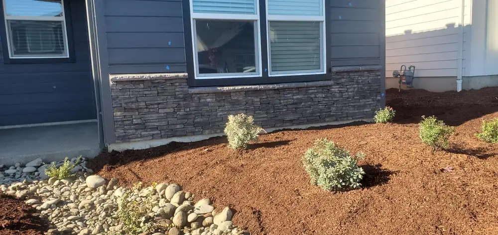 Gray stone veneer wainscot on home exterior with landscaping Oregon